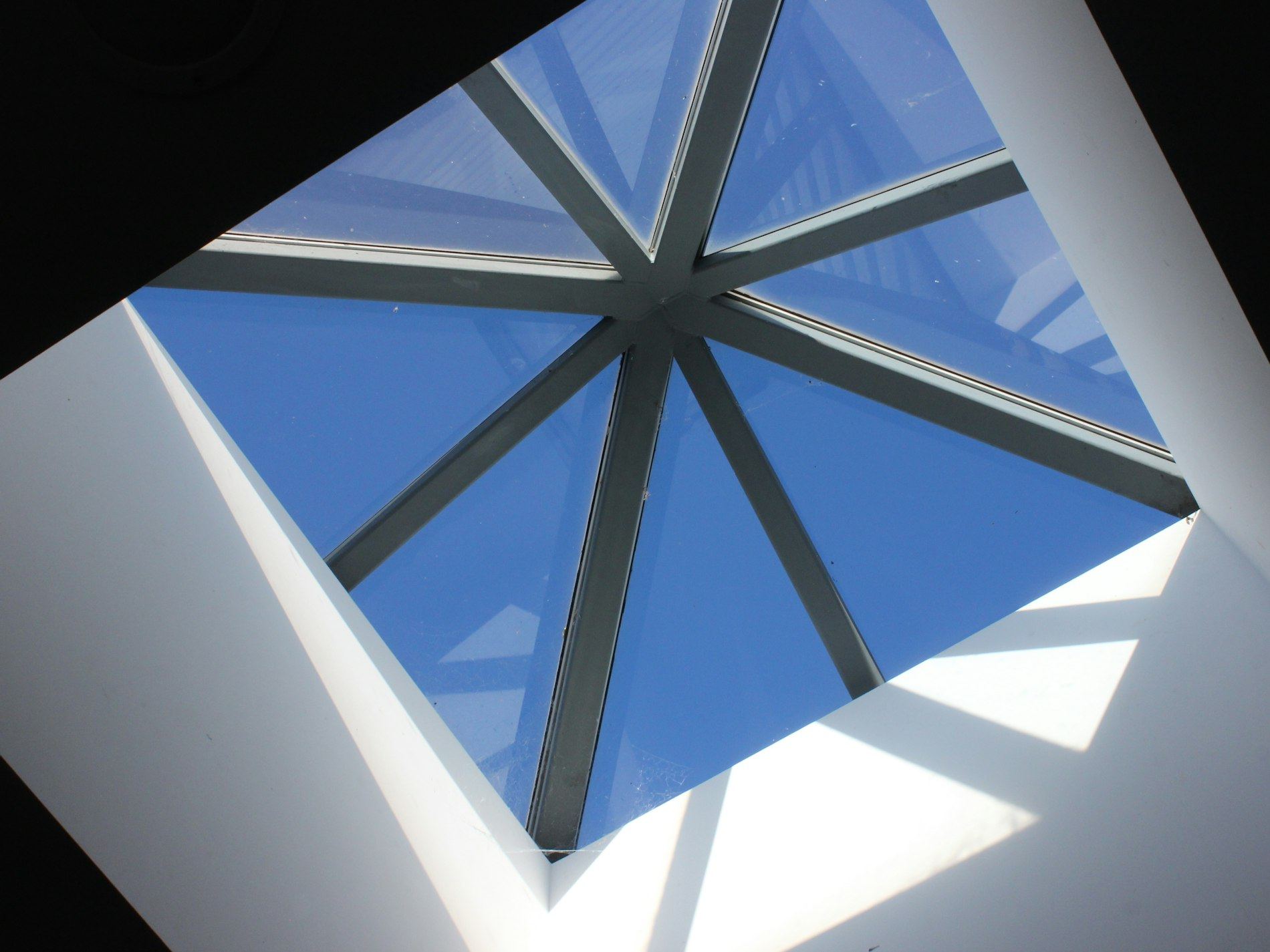 Looking up through a square skylight at a blue sky