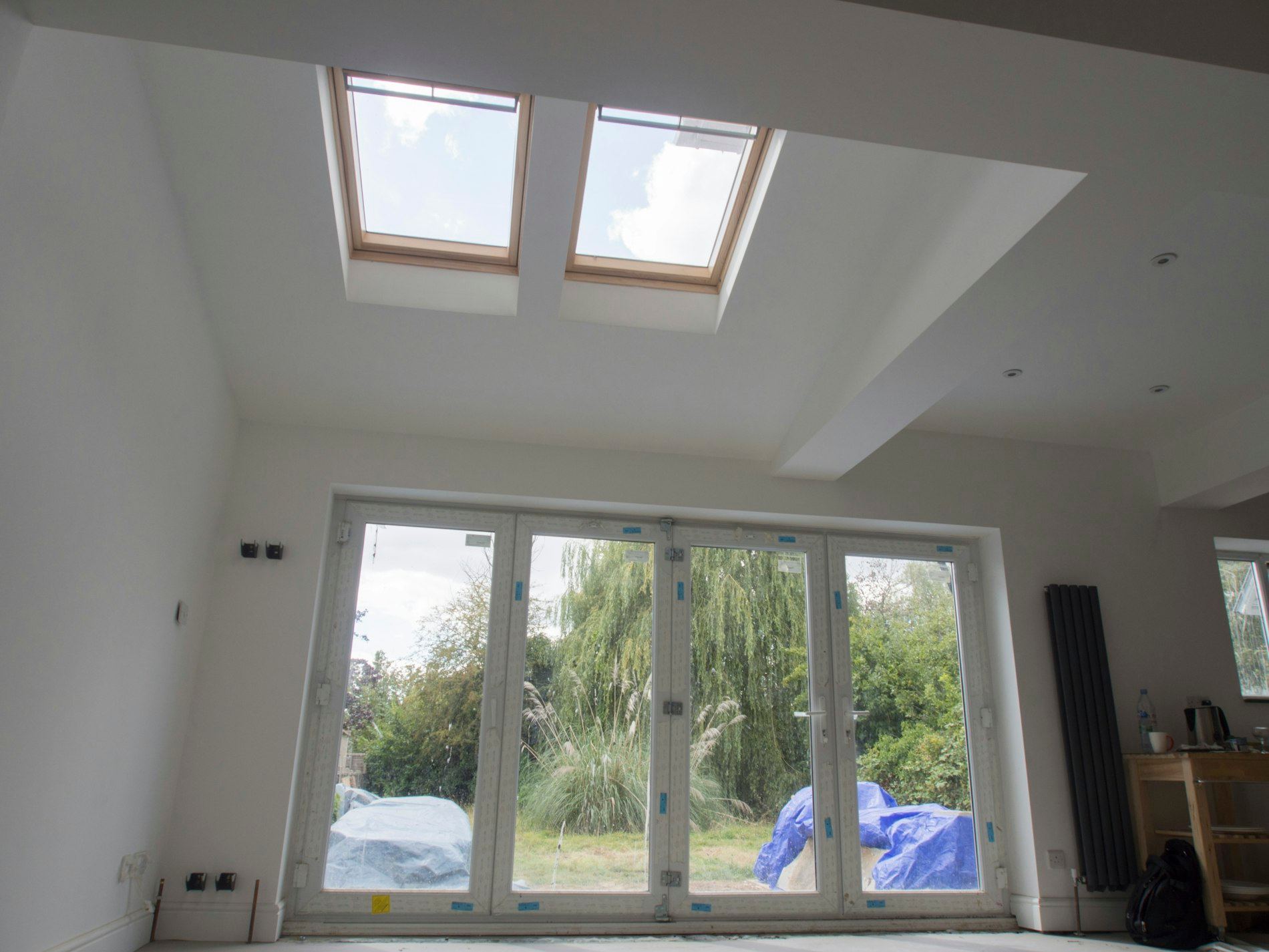 Interior room with skylights and bifold doors overlooking a garden
